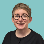 Image of a woman, with short hair, smiling and wearing glasses