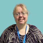 Image of a smiling woman wearing glasses with long strawberry blonde hair tied back